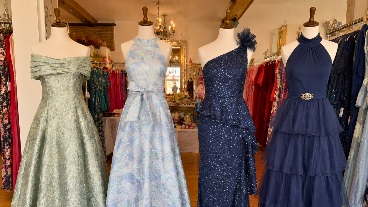 Wedding guest dresses in different styles and colors displayed in a boutique, showcasing formal, semi-formal, and cocktail attire options for wedding dress codes.