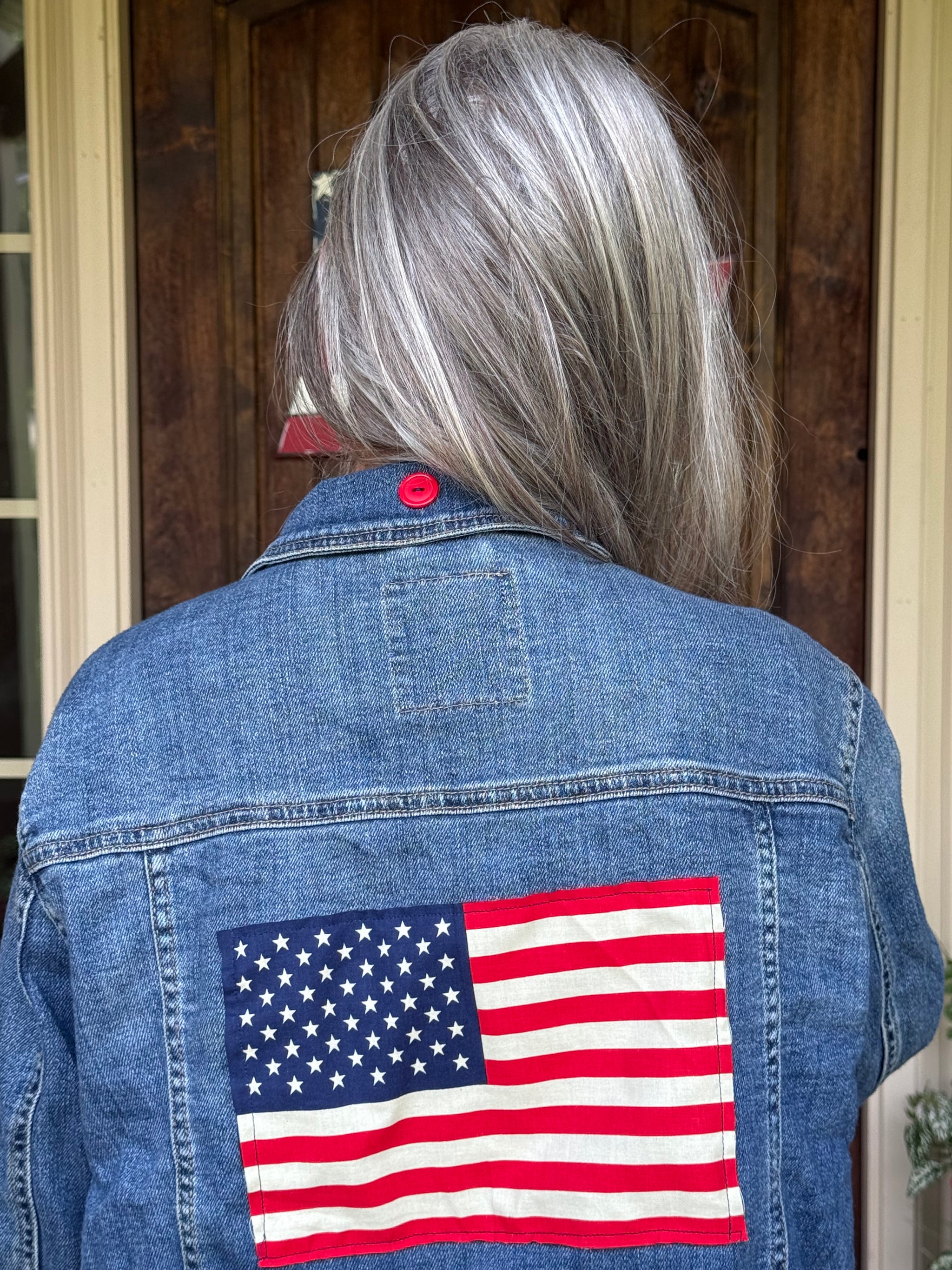 Back view of an upcycled Mossimo denim jacket with an American flag panel at Dover Grace Boutique in Watkinsville, Georgia.