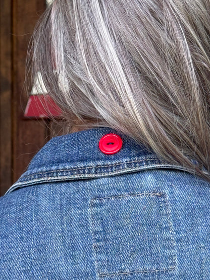 Red button accent on the back collar of an upcycled Mossimo denim jacket at Dover Grace Boutique in Watkinsville, Georgia.