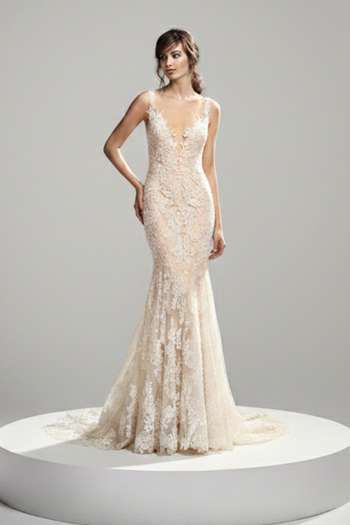 This floor-length mermaid-style bridal gown features a fitted silhouette crafted from elaborate lace with intricate floral and scroll patterns throughout. The dress has a deep, plunging V-shaped open back that dips to the natural waistline, framed by delicate lace straps. The design tapers at the knees and flares out into a dramatic, scalloped lace train that spreads across the floor.