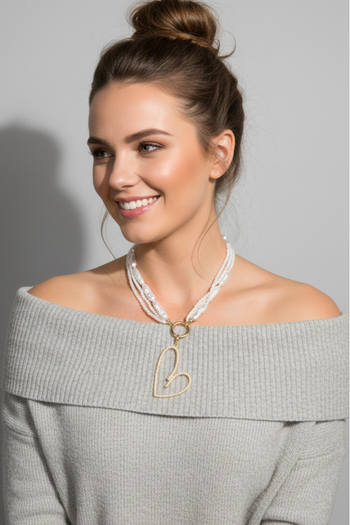 Gold-toned multi-strand necklace featuring mixed pearls and a large open-heart pendant encrusted with small white pearls.