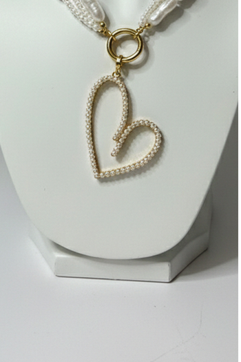 Necklace with a heart-shaped pearl pendant on a white stand