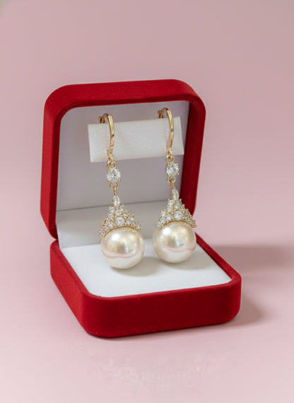 Gold-tone earrings with a graduated pearl drop topped by a fine cubic zirconia crown.