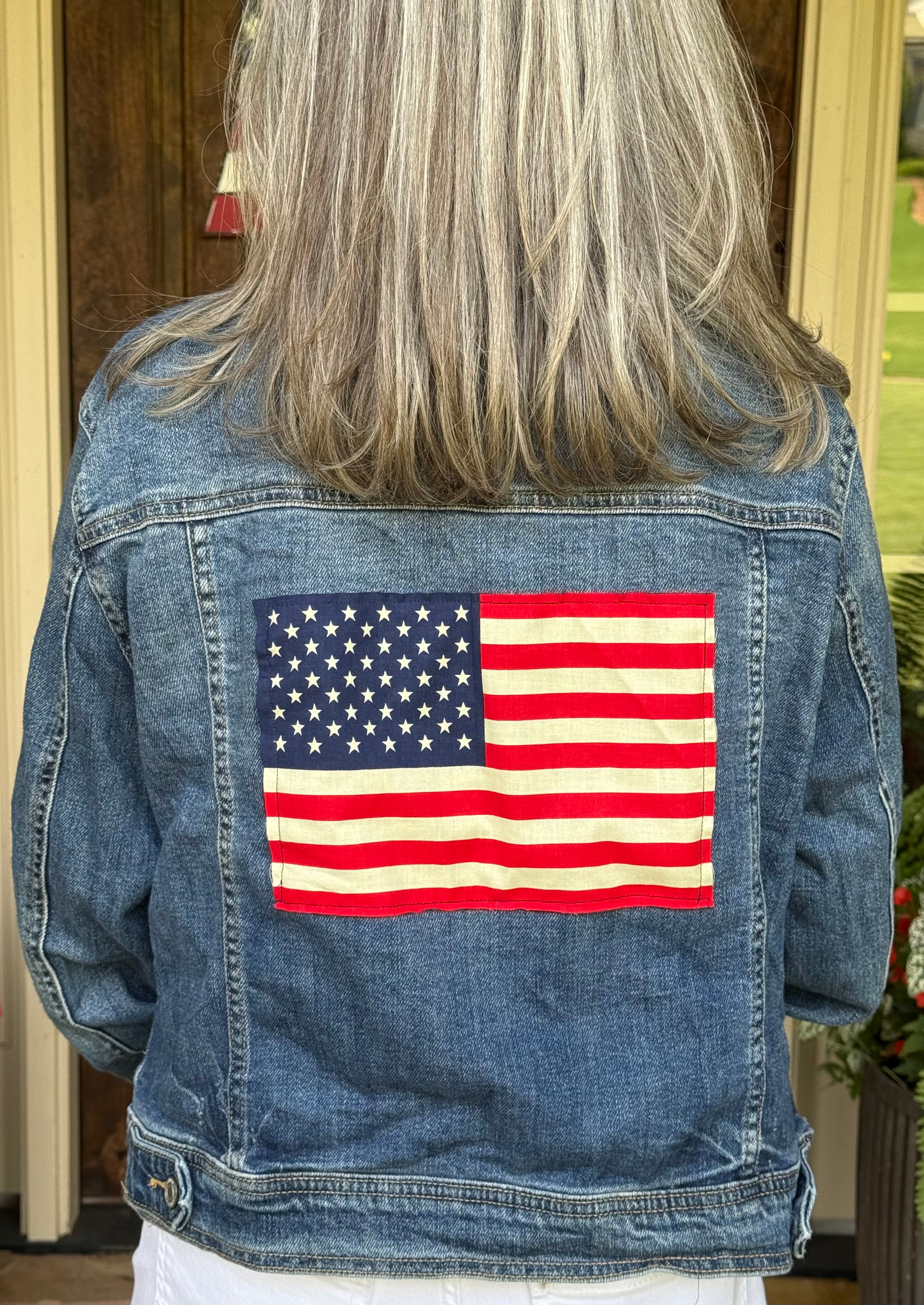 Upcycled Mossimo denim jacket with a hand-stitched American flag panel on the back at Dover Grace Boutique in Watkinsville, Georgia.