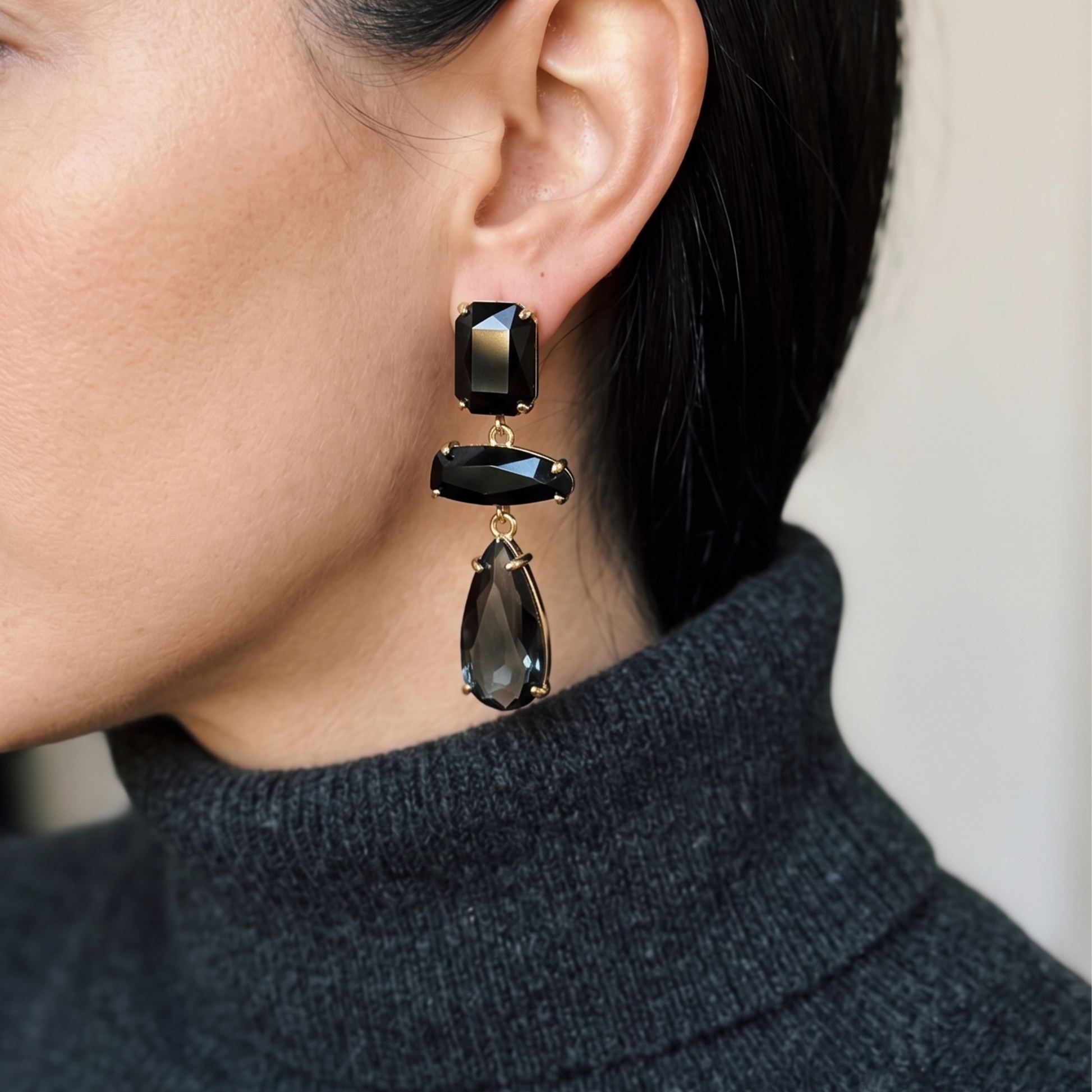 Gold-tone earrings with three stacked black crystal stones in a vertical drop.
