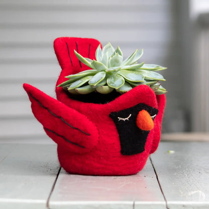 Red bird-shaped planter with a succulent plant on a wooden surface.