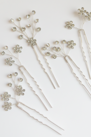 A set of five silver-toned hair pins featuring delicate wire branches topped with shimmering floral and round crystals.