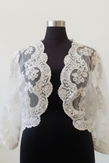 This elegant white lace bridal bolero features an open front and three-quarter length sleeves. Crafted from sheer tulle with floral lace appliqués and subtle sequins, it is shown on a black mannequin against a minimalist off-white background.