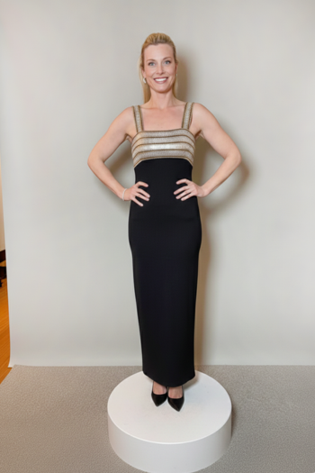 A floor-length black column dress featuring a square neckline and wide straps, with a metallic gold and silver horizontal striped bodice.