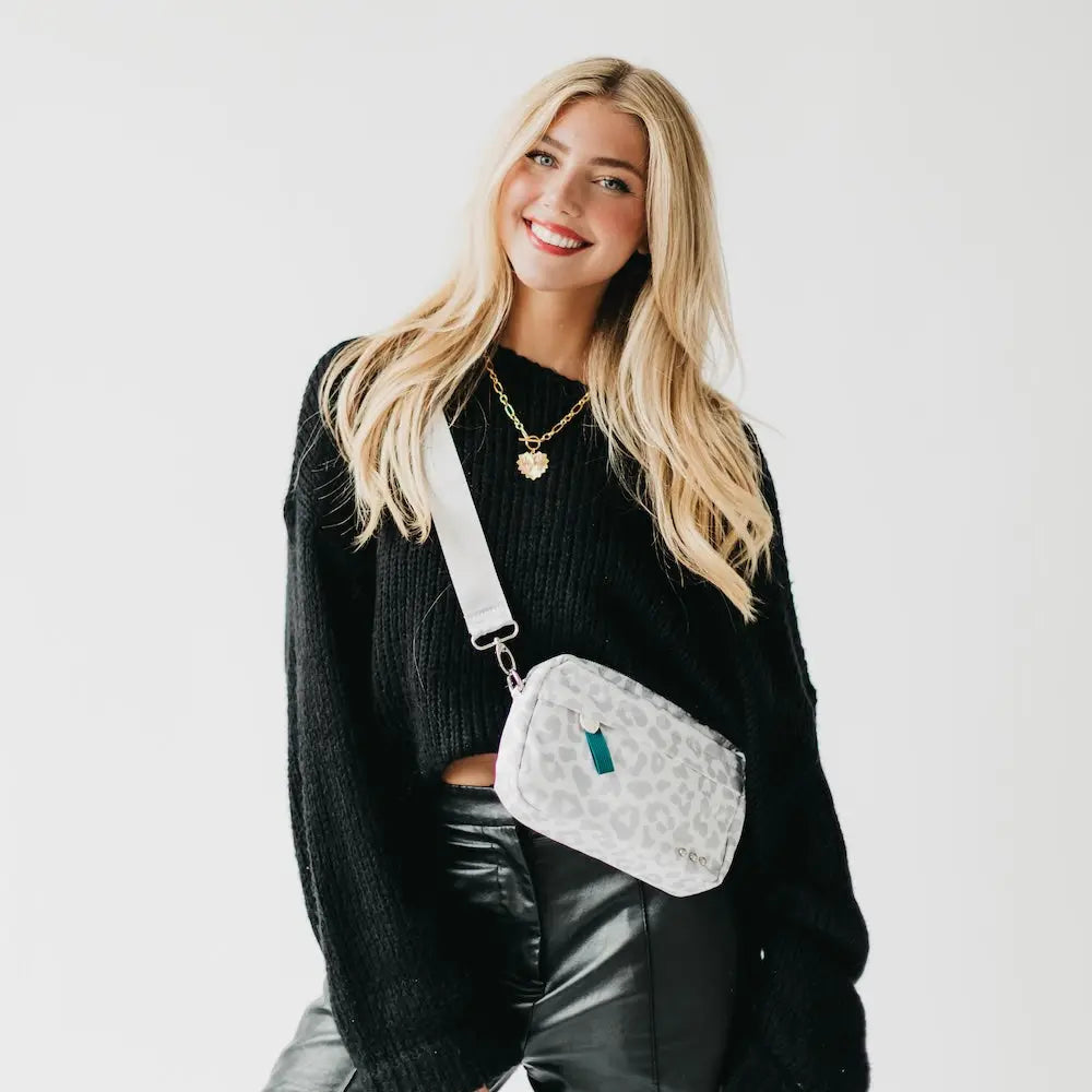 A white textured crossbody bag on a light gray background