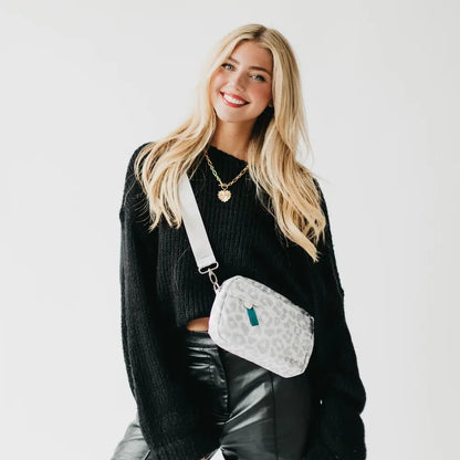 A white textured crossbody bag on a light gray background