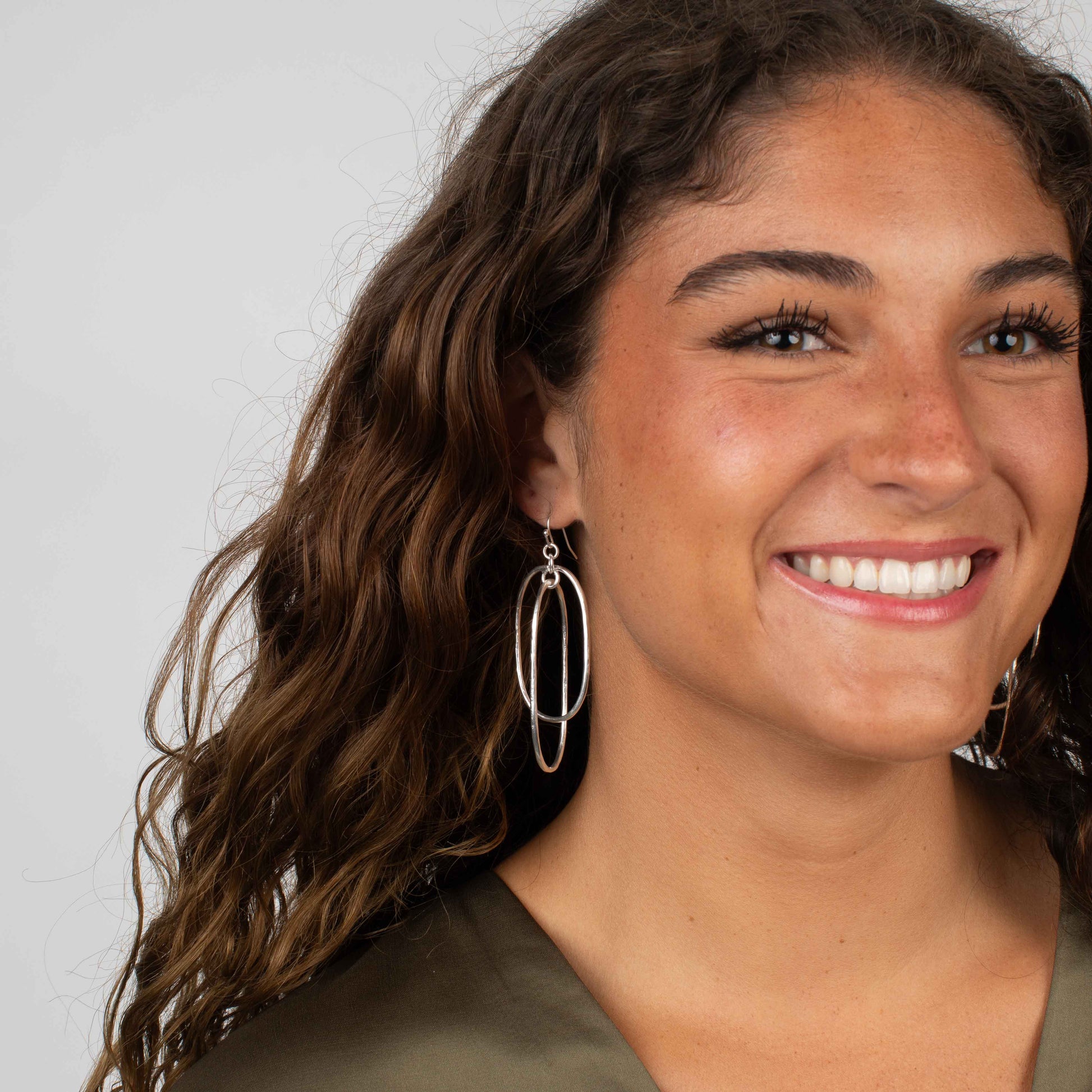 Gold-tone earrings with two layered oval hoops in a geometric drop silhouette.