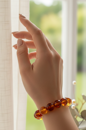 amber bead bracelet, featuring polished, translucent round beads in various shades of honey and cognac orange.