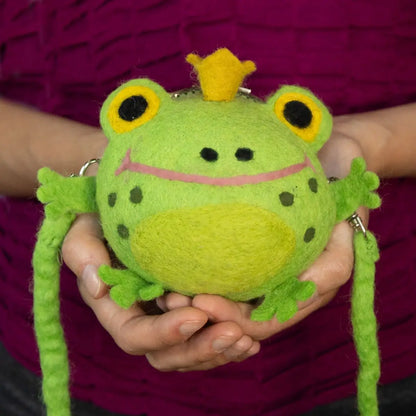 A green felt purse shaped like a frog wearing a yellow crown with a shoulder strap.