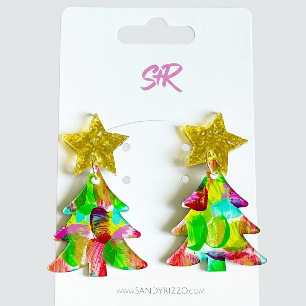 Colorful tree-shaped earrings with gold stars on a Sandy Rizzo branded card.