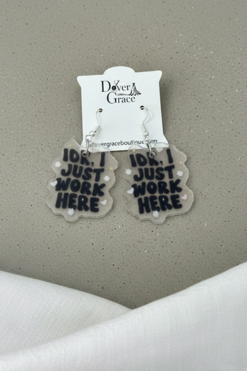 Acrylic earrings with text reading 'IDK, I Just Work Here' on a gray background.