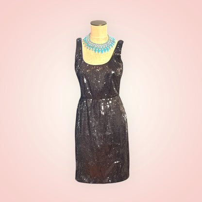 Black sequin dress on a mannequin with a pink gradient background