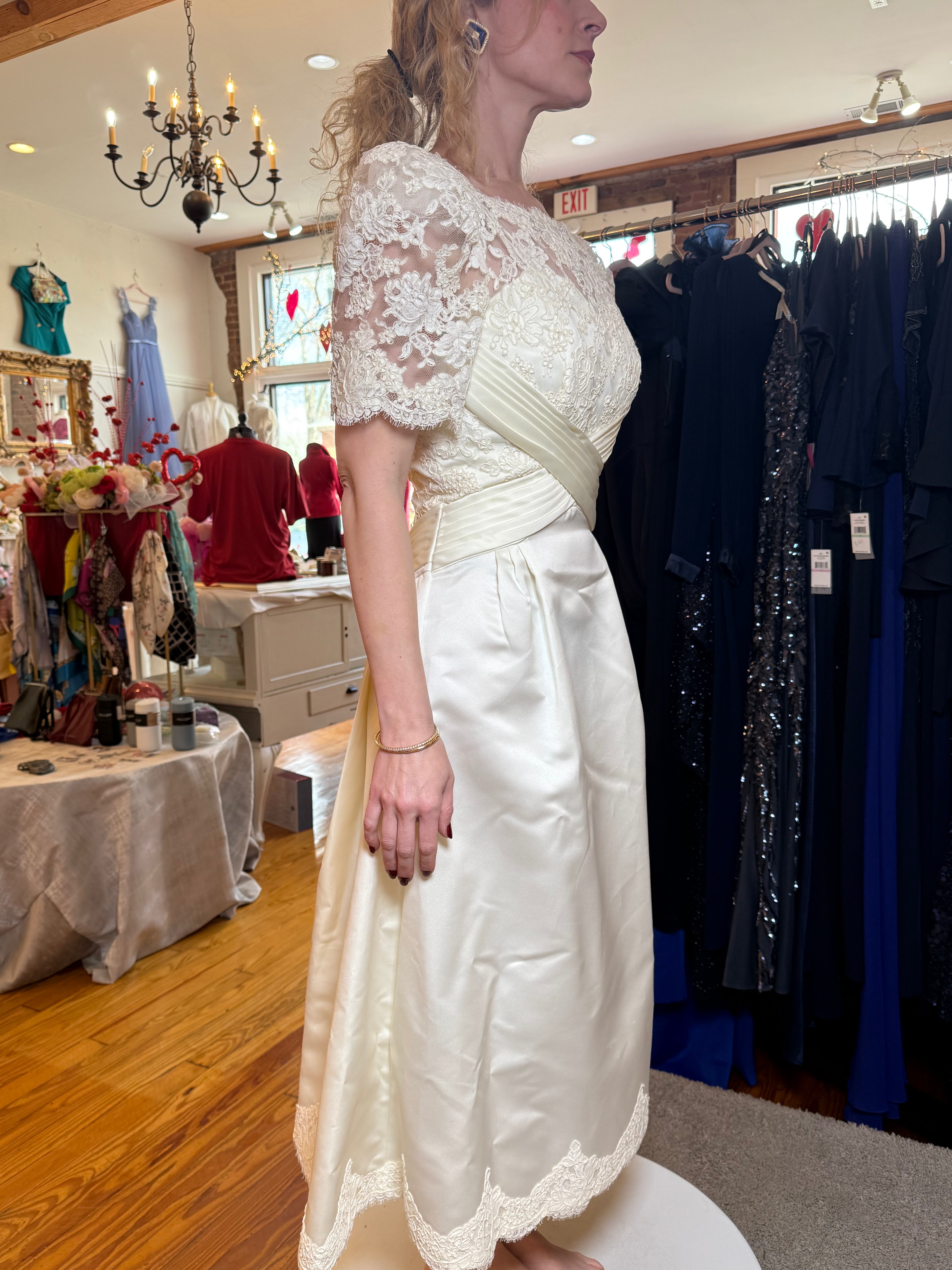 Woman wearing a white lace dress in a clothing store.