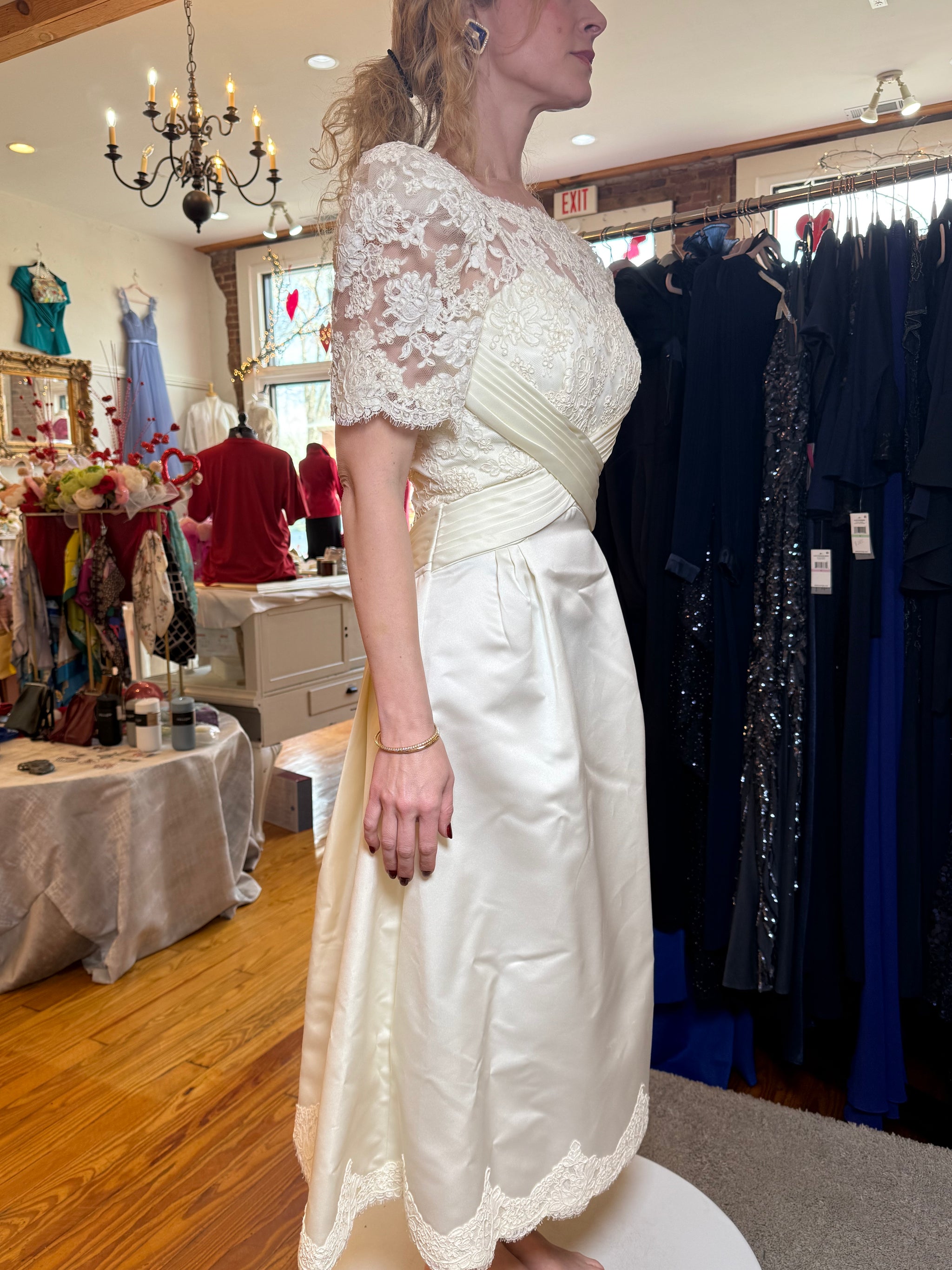 Woman wearing a white lace dress in a clothing store.