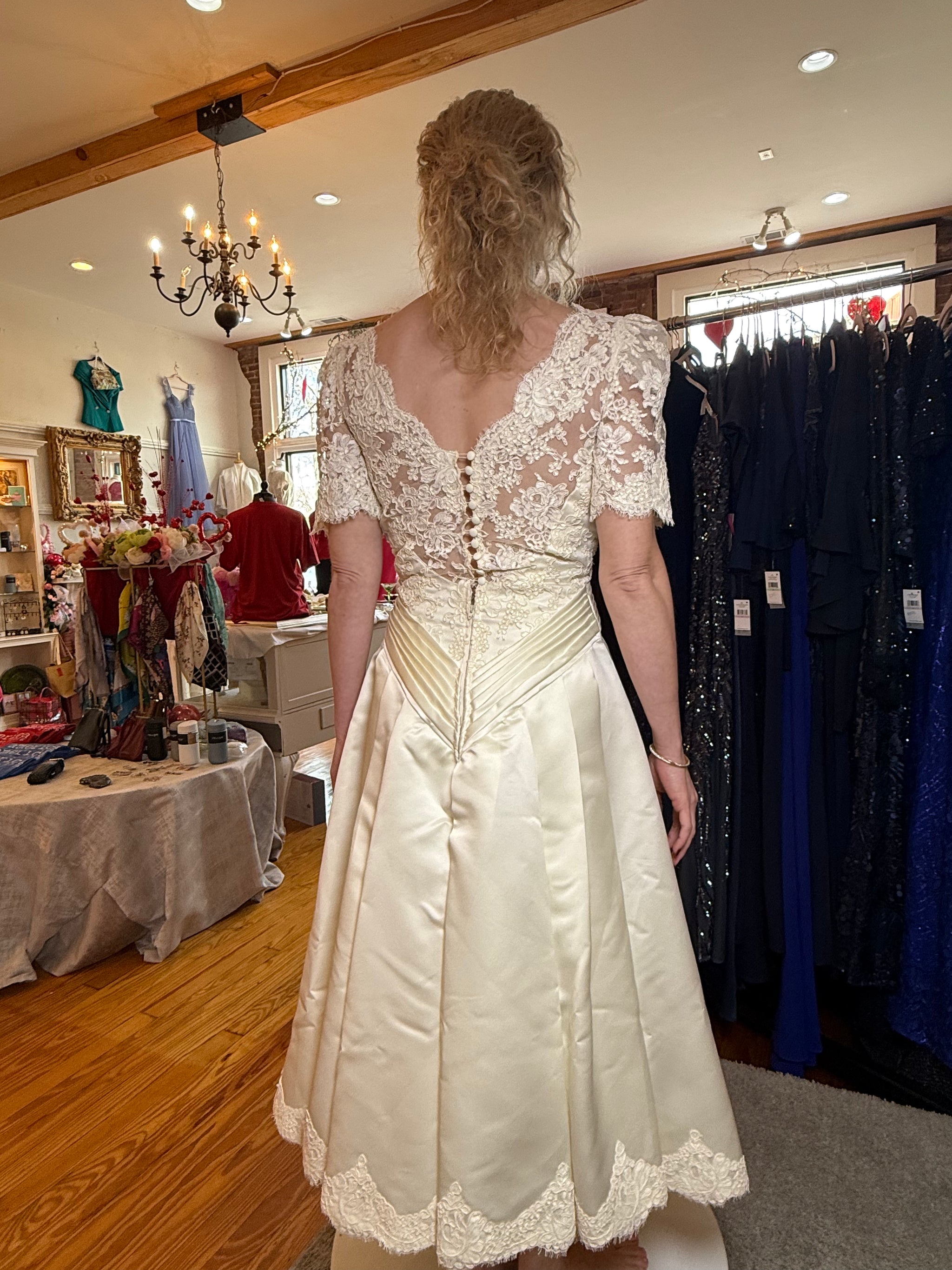 Woman wearing a white lace dress in a clothing store.