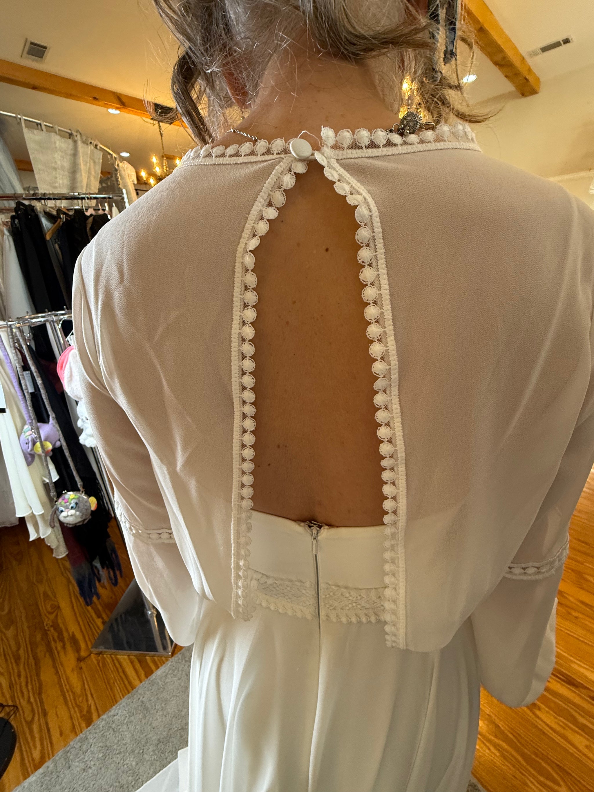 White dress with decorative back design in a store setting