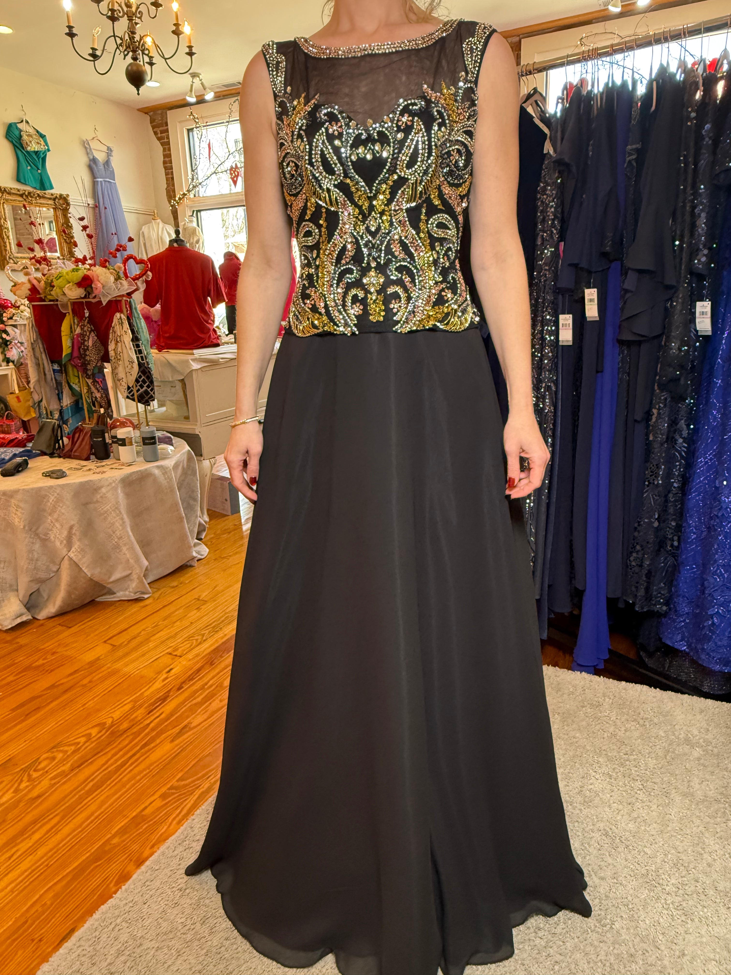 Woman wearing a black evening gown with a patterned top in a clothing store.