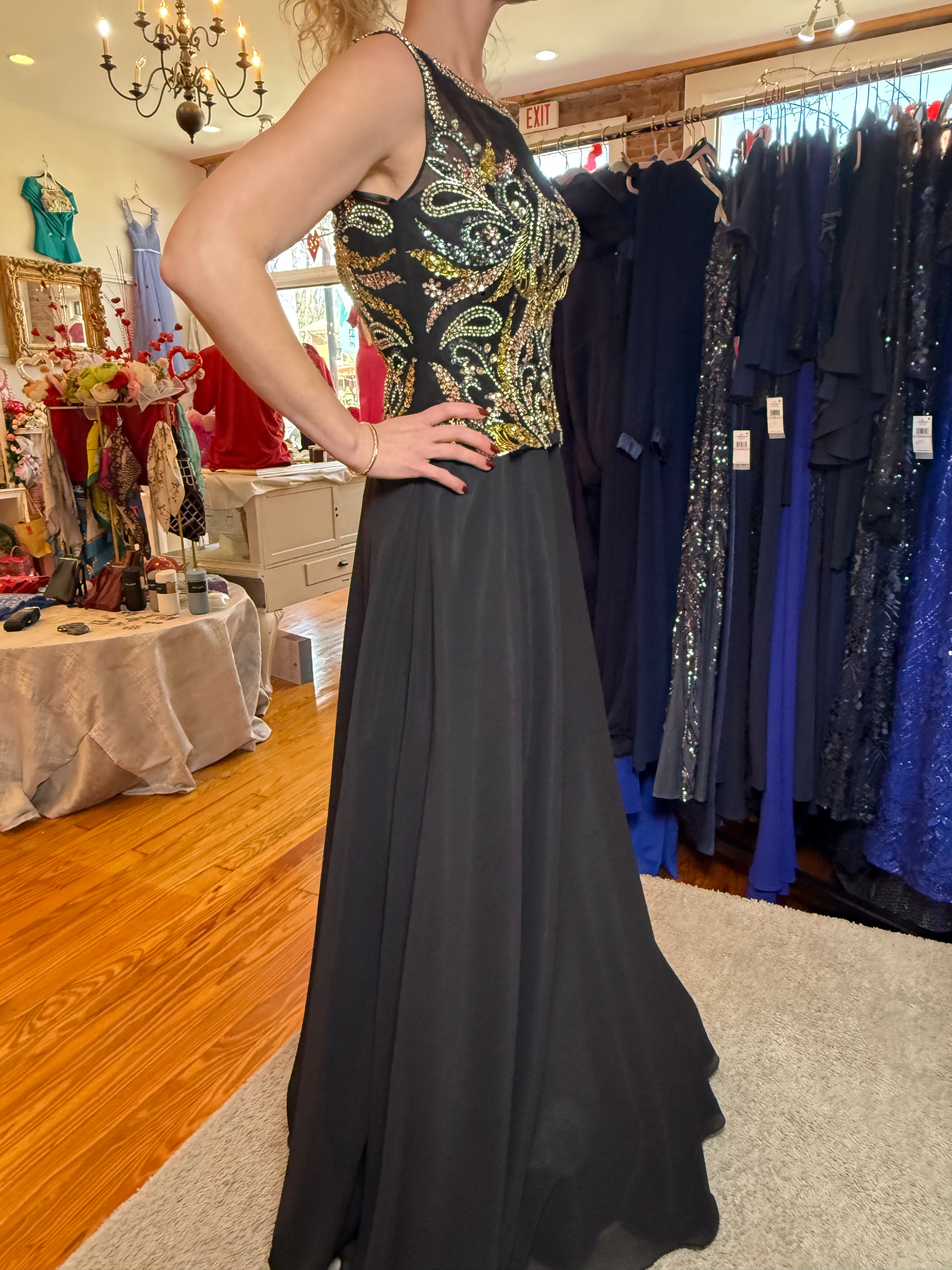 Person wearing a black evening gown with a patterned top in a store setting.