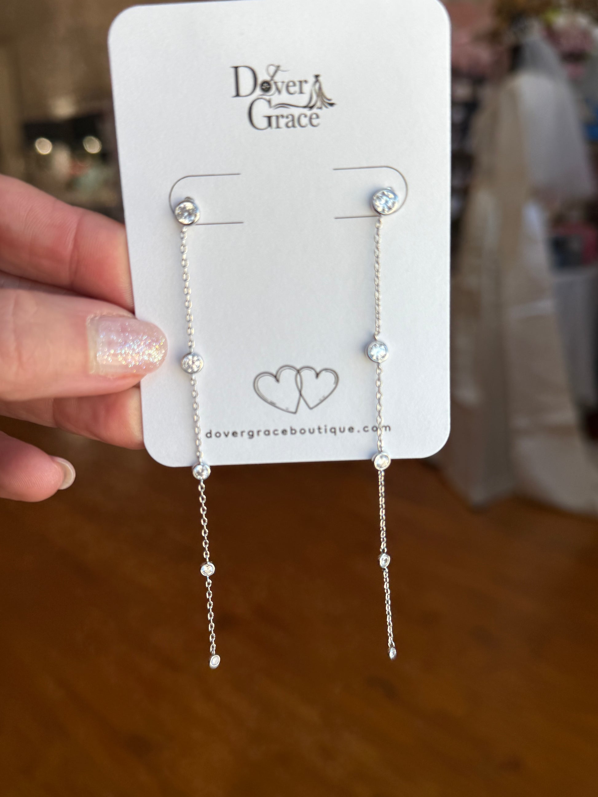 Long silver earrings with a vertical chain of bezel-set round CZ crystals.