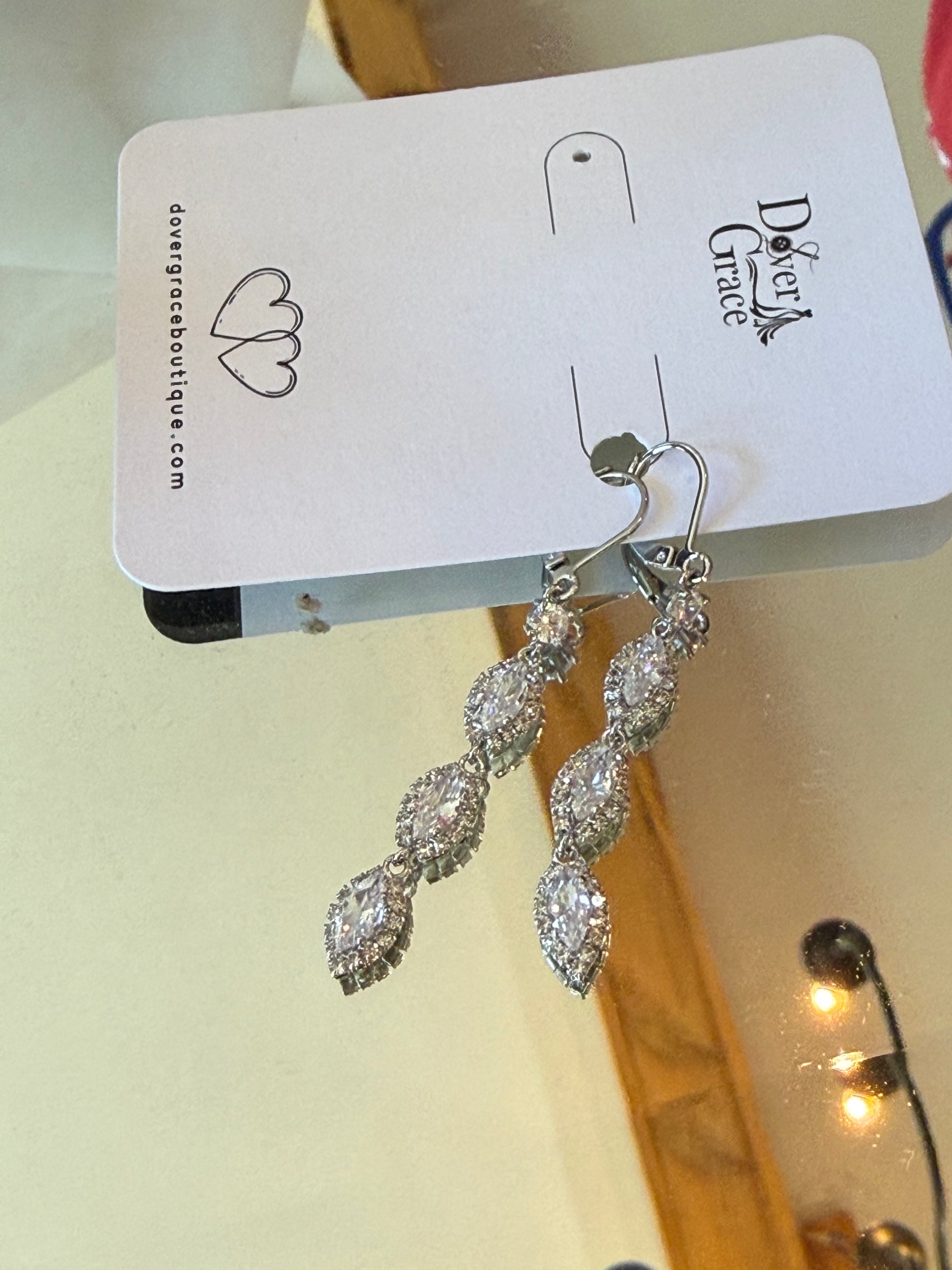 Silver earrings with three marquise-cut CZ crystals in pave halo settings, descending in size.