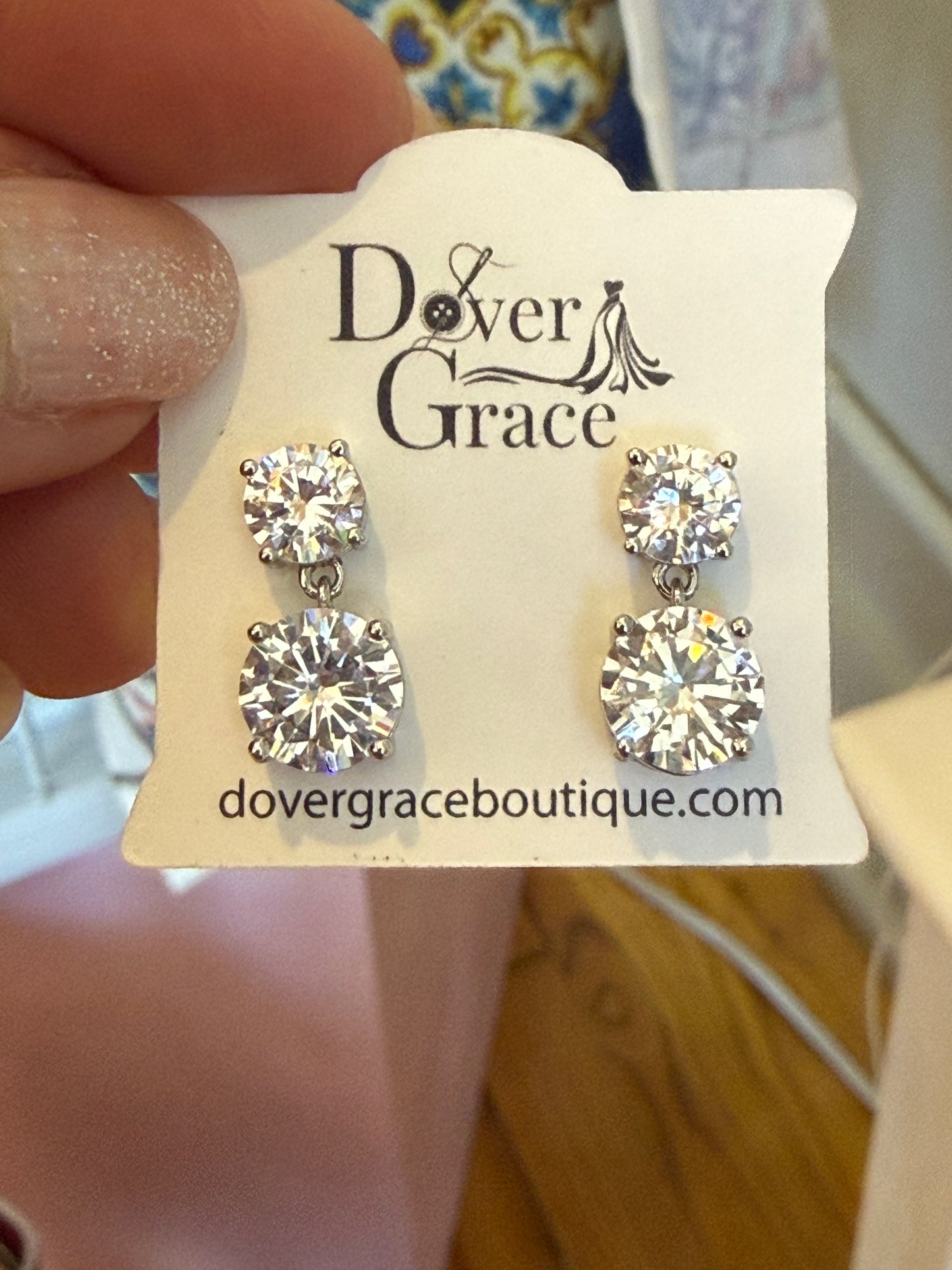 Silver double-drop stud earrings with two round brilliant moissanite stones.