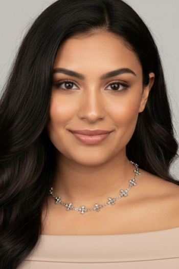 Silver-toned necklace featuring a delicate chain interspersed with small, polished four-point star or floral-style charms.