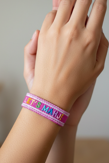 Woven magenta friendship bracelet  featuring the phrase "LET'S MAHJ!" embroidered in vibrant, multicolored letters.