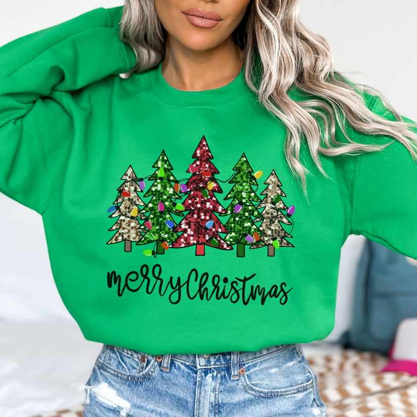 Green sweatshirt with Christmas tree design and 'Merry Christmas' text worn by a person.
