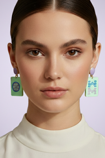 Close-up of a woman wearing colorful earrings with a plain background