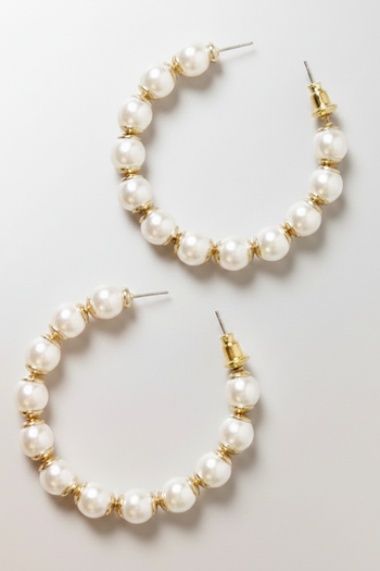 Gold-tone C-shaped hoop earrings with white round pearls separated by small ribbed gold spacer beads.
