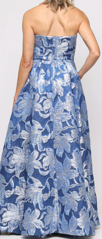 Back view of Alex Evenings blue floral jacquard strapless ballgown showing structured bodice, full A-line skirt, and hidden pockets