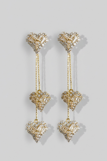 Gold heart-shaped earrings with dangling elements on a light gray background