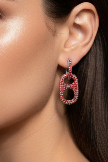 Close-up of a woman's ear wearing a sparkling red earring.