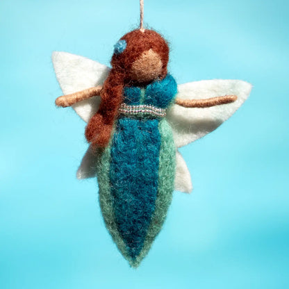 Felt fairy ornament with brown hair and blue dress on a light blue background