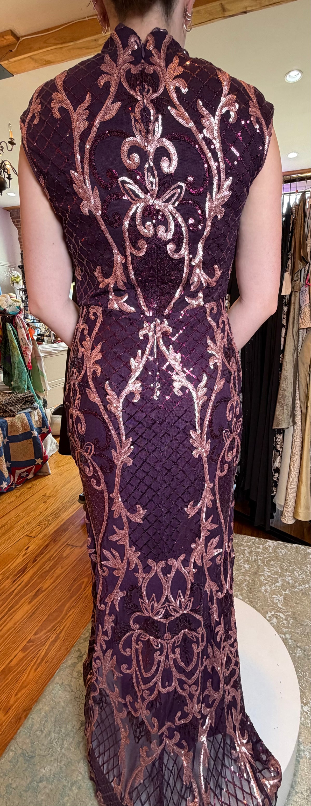 Back view of a wine evening gown with rose sequin embroidery and a fitted silhouette.