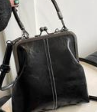 black women’s satchel handbag with structured frame, top handle, and adjustable shoulder strap.