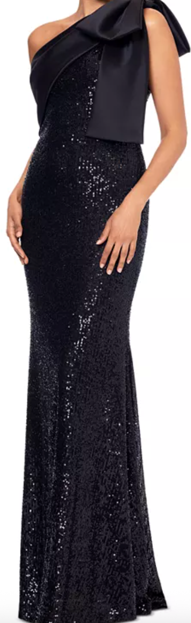 Side view of a fitted black sequin gown with a large satin bow at one shoulder.