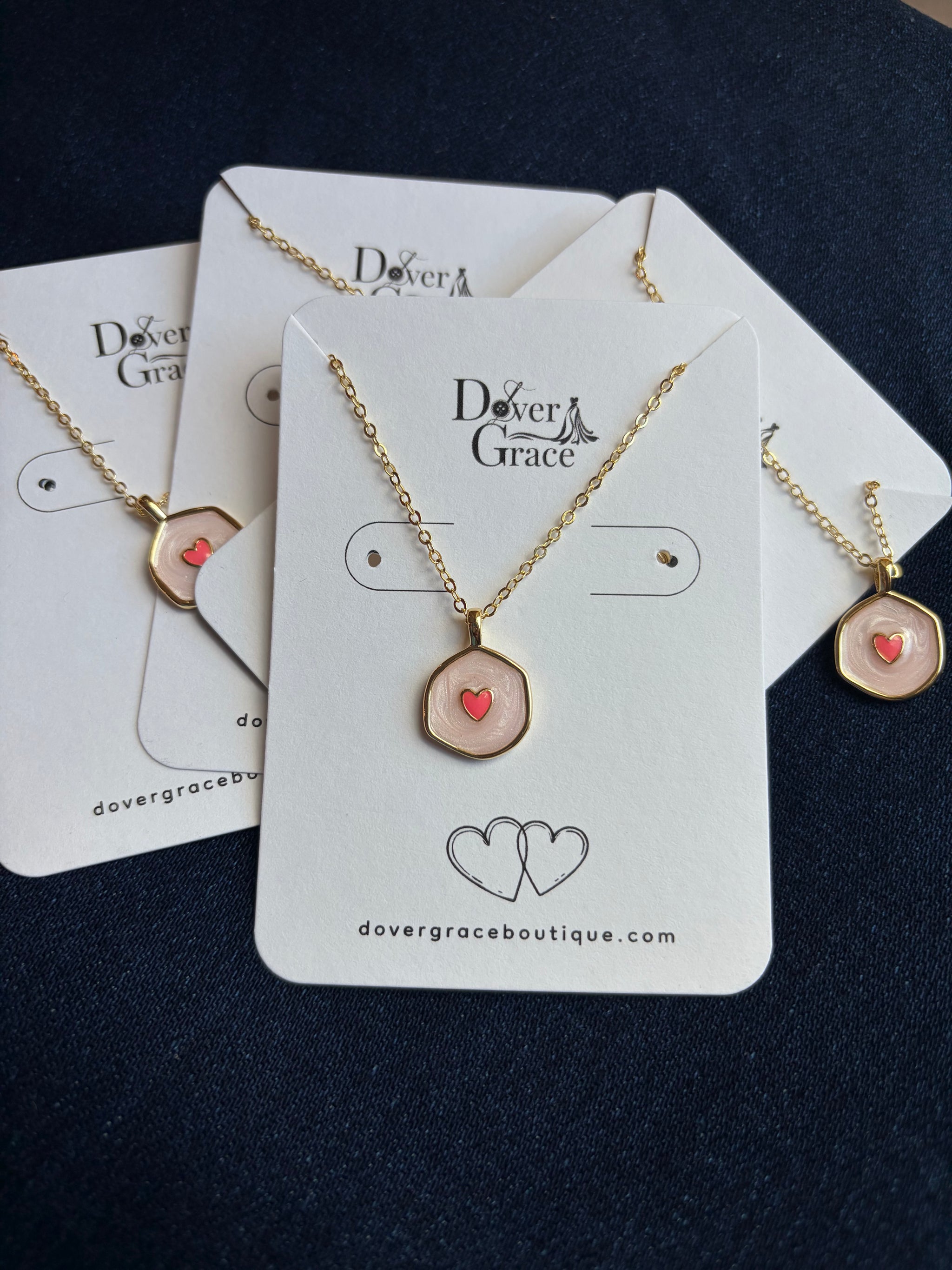 Blush heart pendant necklaces on display cards at Dover Grace Boutique in Watkinsville, Georgia.
