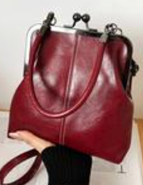 Vintage inspired burgundy women’s satchel handbag with structured frame, top handle, and adjustable shoulder strap.