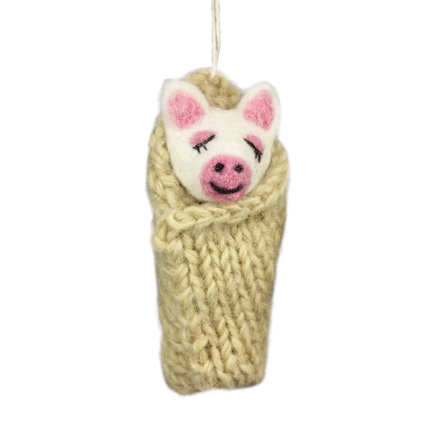 Knitted pig ornament with a beige scarf on a white background