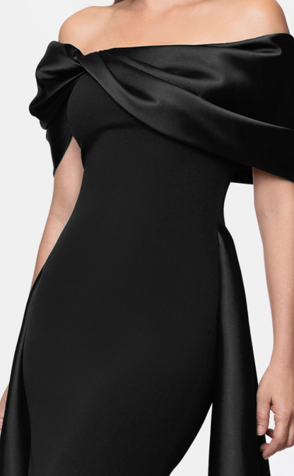 Black off-shoulder satin cape gown with pleated overlay at Dover Grace Boutique in Watkinsville, Georgia.