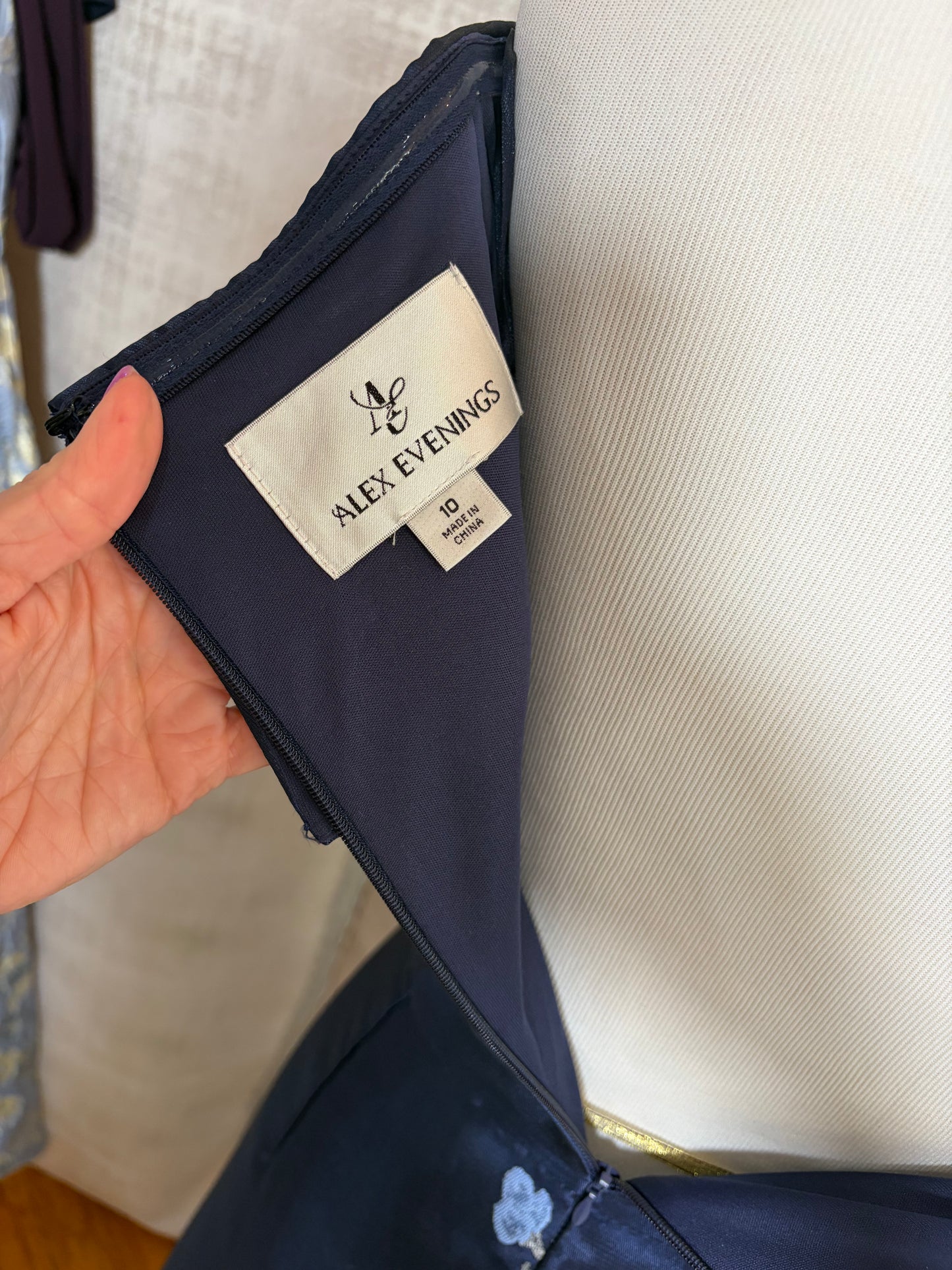Navy floral off-shoulder A-line evening gown with V-neckline at Dover Grace Boutique in Watkinsville, Georgia.