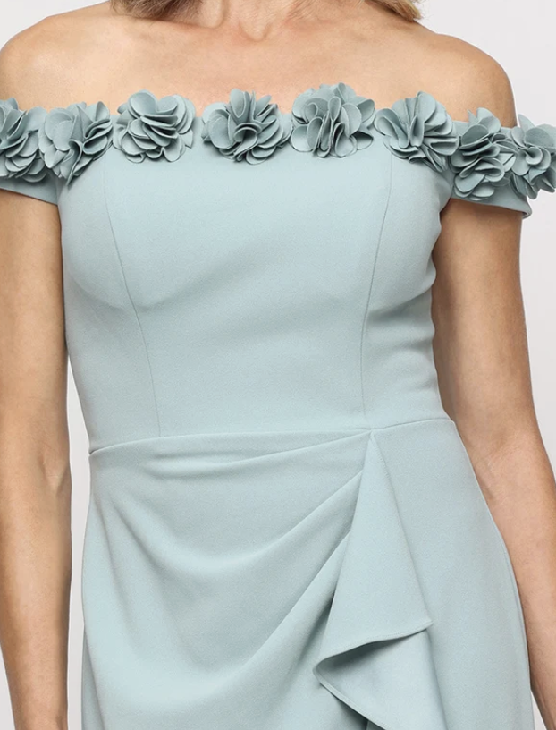 Sage green off-shoulder gown with 3D flower neckline at Dover Grace Boutique in Watkinsville, Georgia.