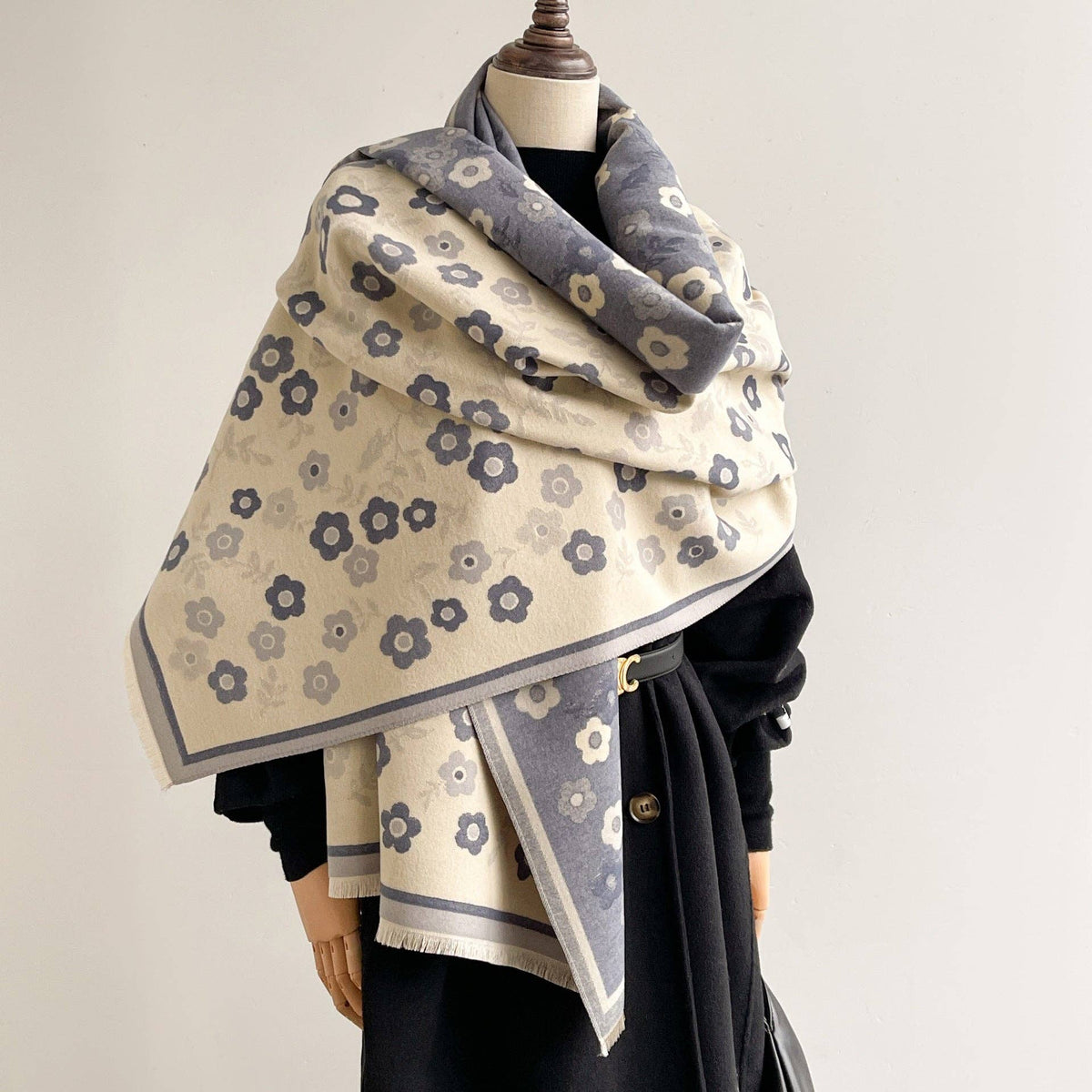 Reversible blue and ivory floral wrap layered over a black outfit on a mannequin.