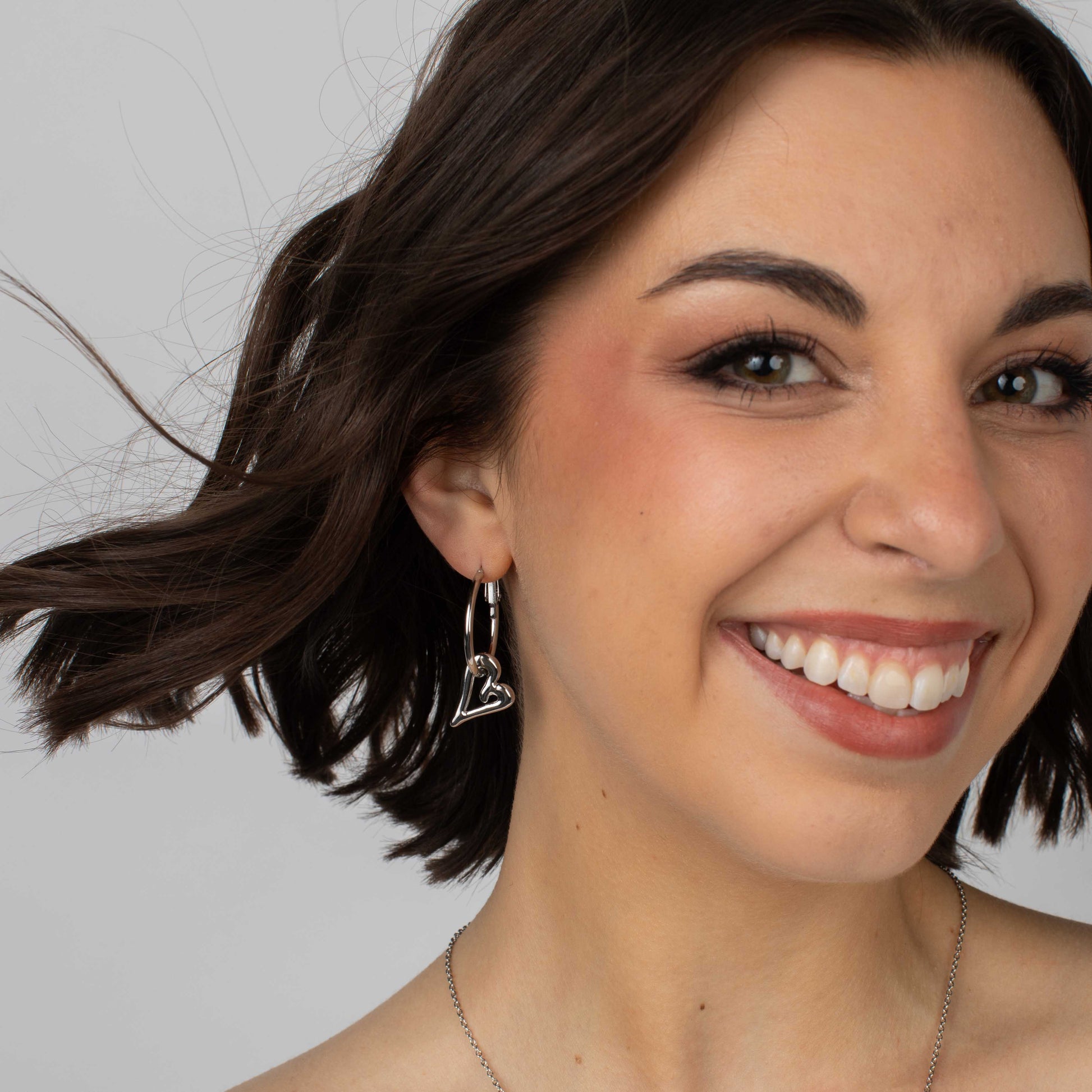 Silver hoop earrings with interchangeable charms shown alongside heart and star options.